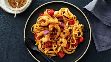 prawn pasta recipe on a black plate and black table