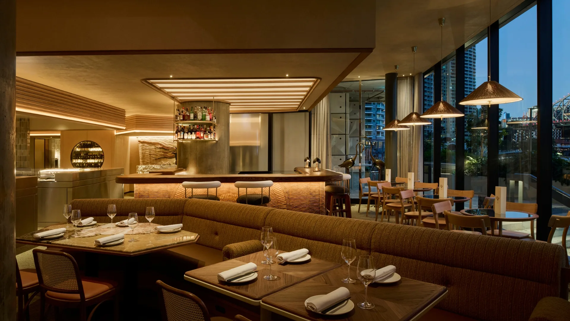 The dining room at Supernormal Brisbane, featuring golden tones and river views.