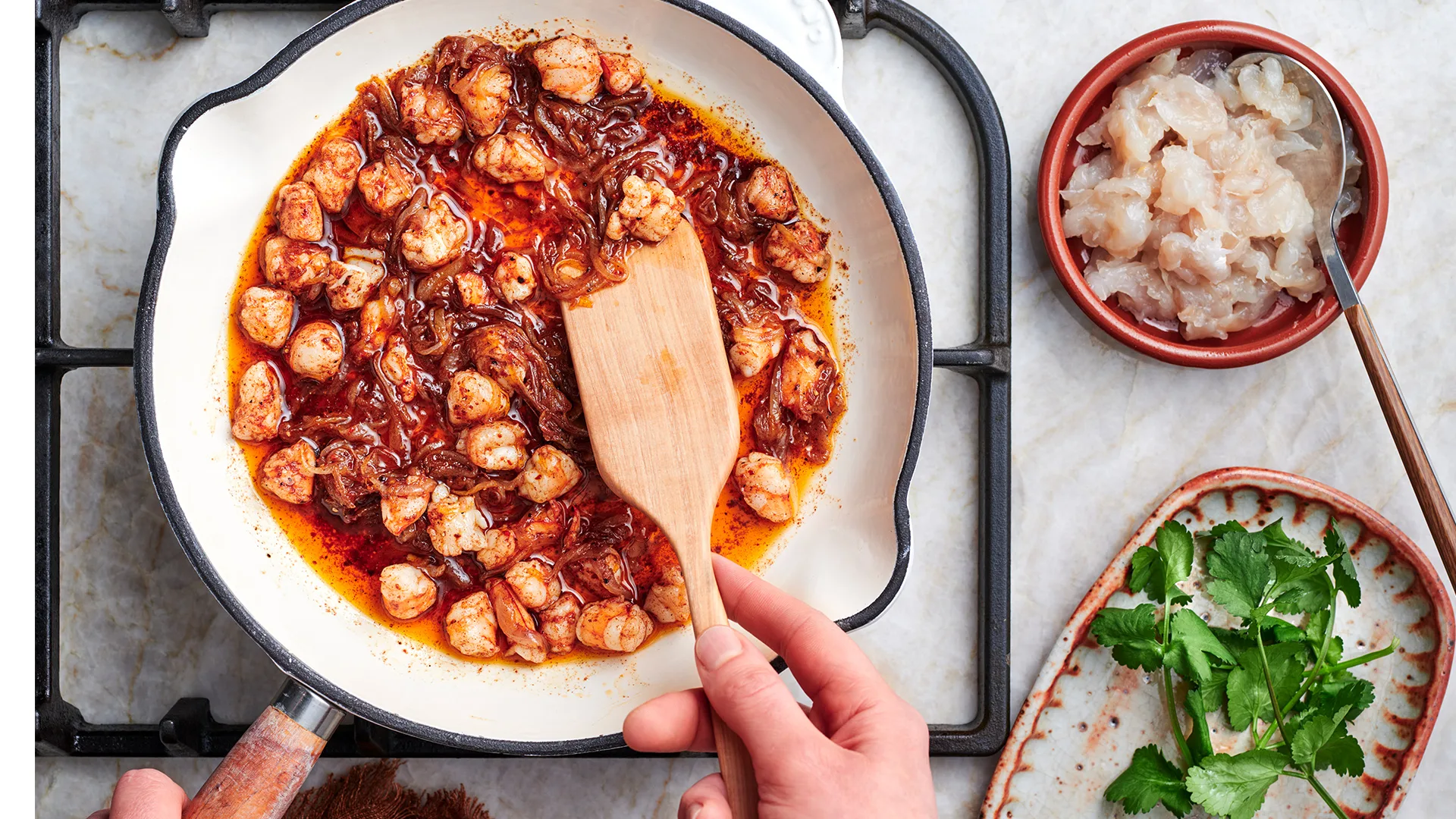 Cooking toum and prawns together in pan.