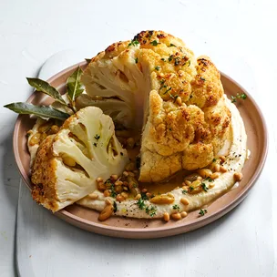 Whole roasted cauliflower with caramelised pine nuts and raisins