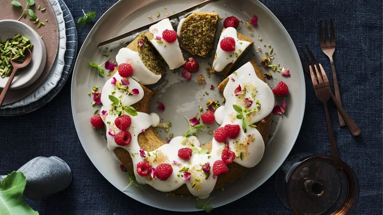 new christmas recipe image depicting a christmas cake with white frosting and raspberries in the shape of a wreath