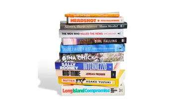 A stack of books, spines facing out, that make up the best books for the summer