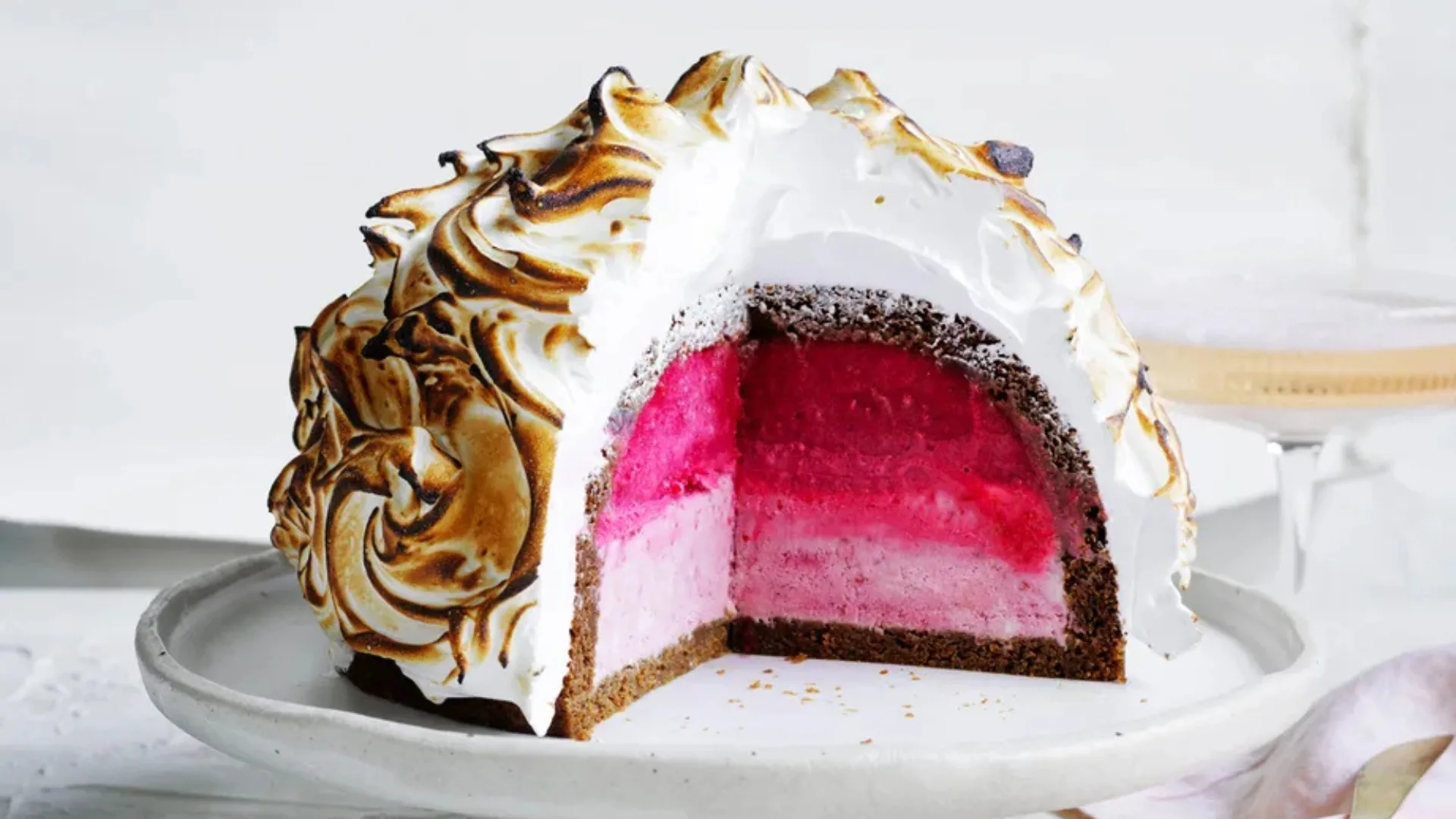 Best Christmas desserts: a semifreddo bomb alaska with layers of raspberry pink ice-cream and torched merringue