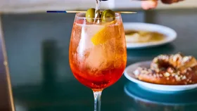 Aperol spritz being poured as a Christmas cocktail recipe