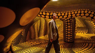 Woman working through Yayoi Kusama exhibition at NGV in Melbourne