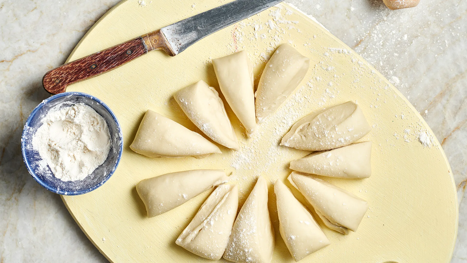 Cutting fillo dough into rounds.