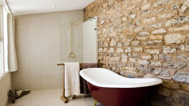 The guest bathroom with stone walls and freestanding bath at Arkaba Homestead, Flinders Ranges.