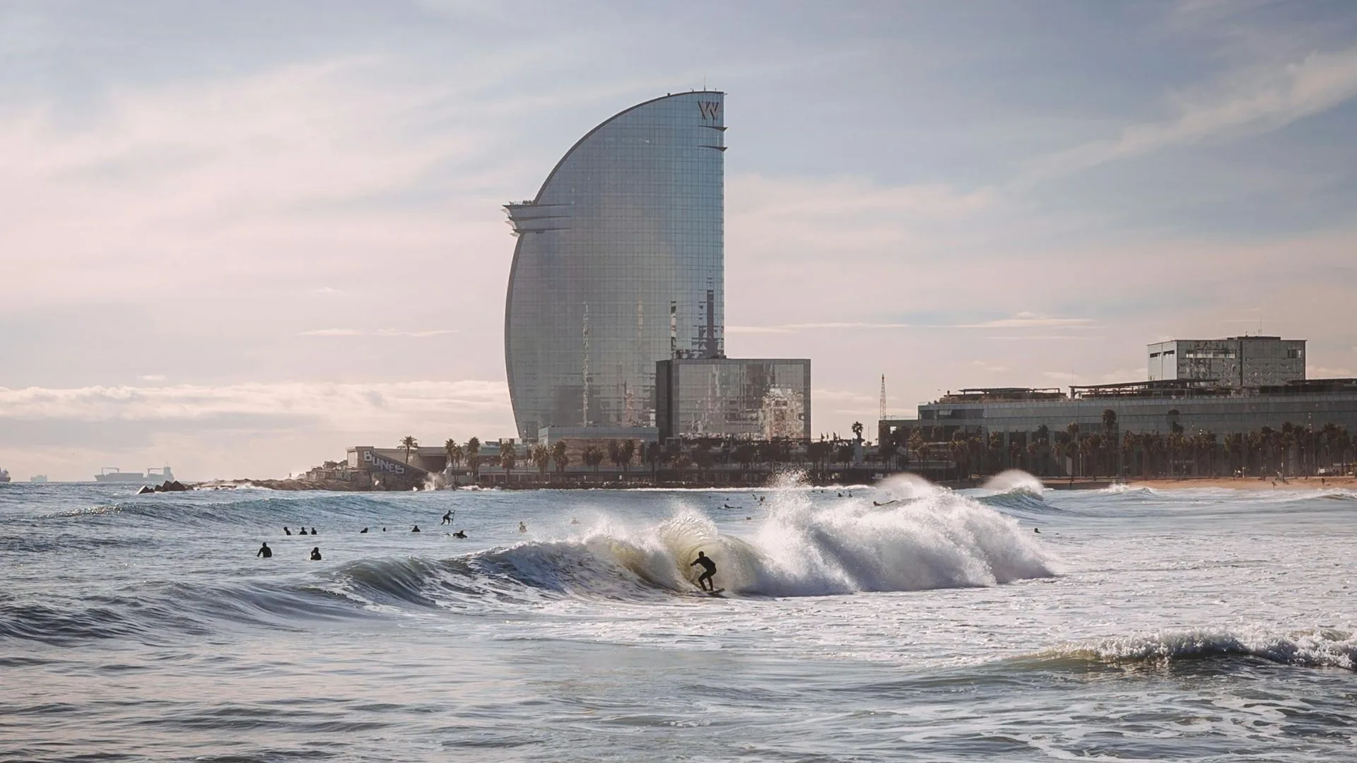 someone surfing at barcelona with W hotel in background