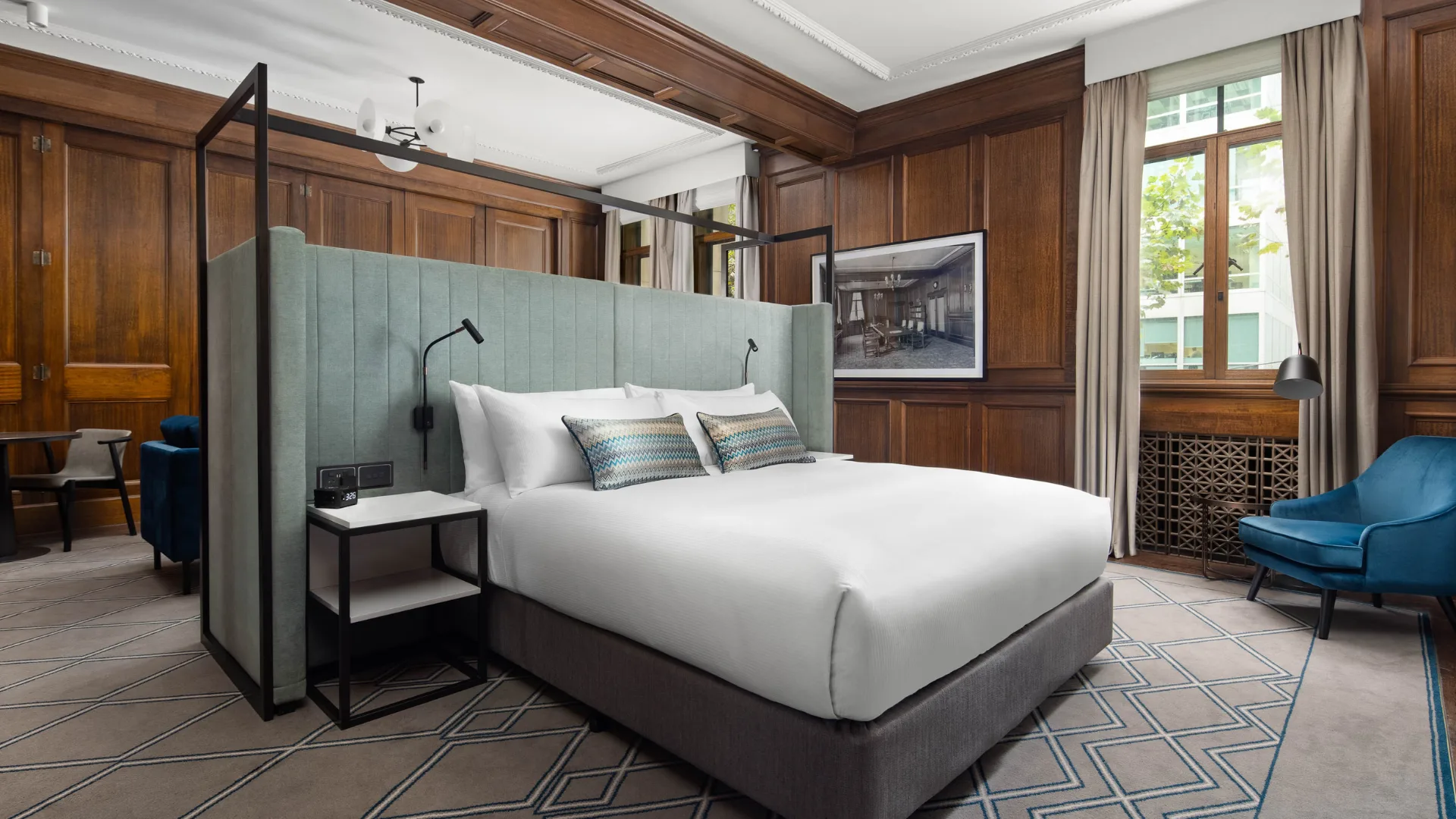 The King Master Suite with original wooden panelling and molded ceilings at Hilton Little Queen Street.