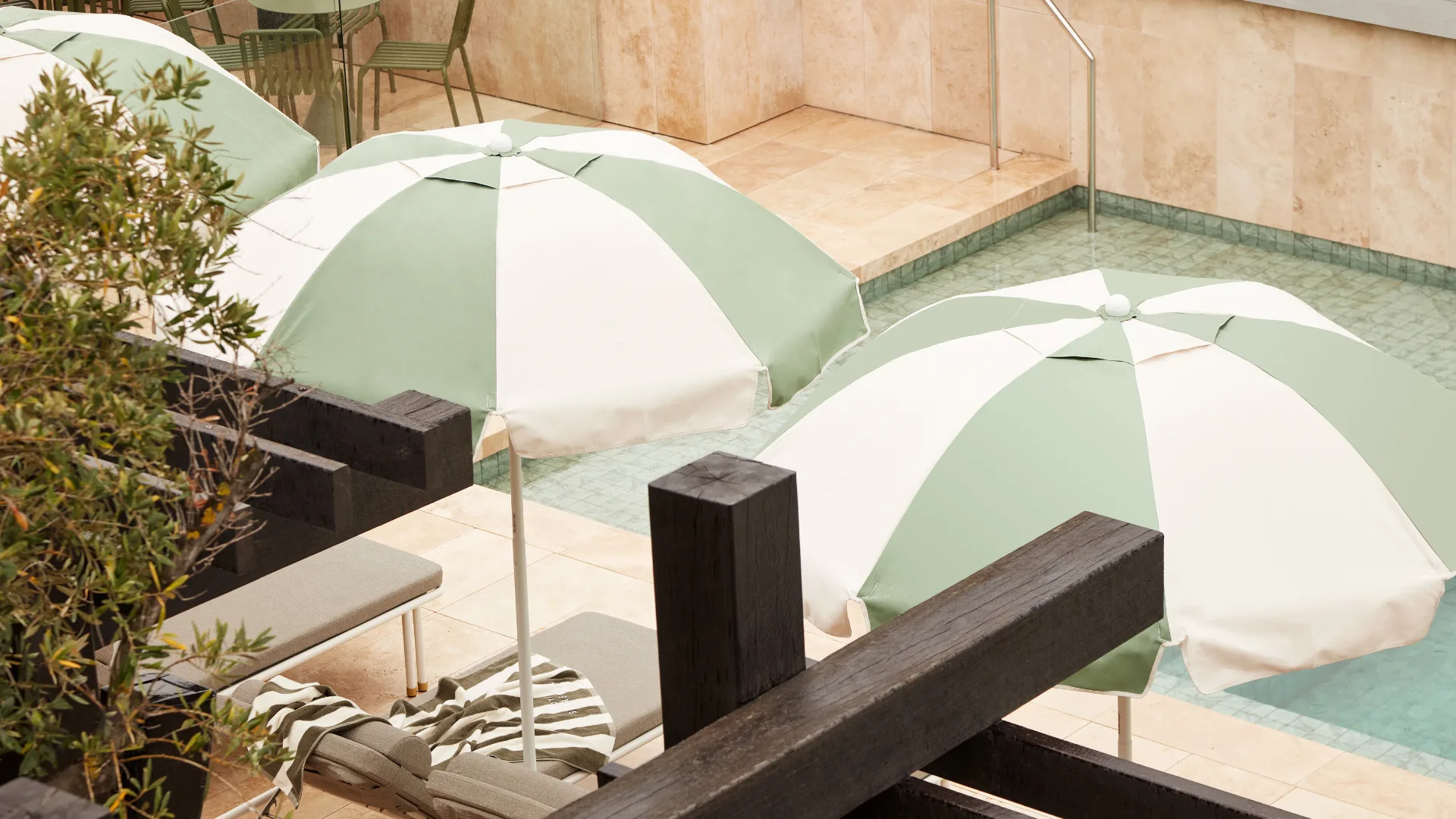Sage green and white striped umbrellas at the outdoor pool at Hotel Sorrento, Mornington Peninsula.
