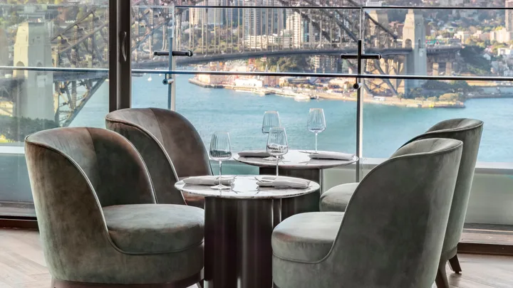 A dining and drinks table setting at Aster Bar overlooking the harbour bridge