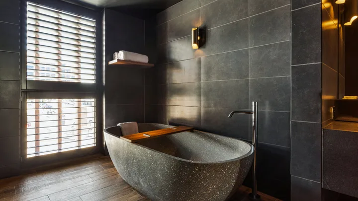 Sleek grey tones and standalone bathtub at MACq01 Hotel, Hobart