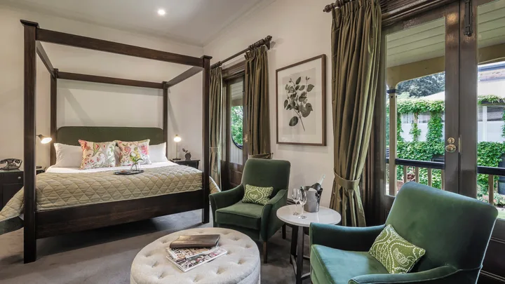 A four poster bed and calm green décor in the Garden View Room at Mount Lofty House