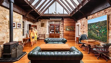 The elegant library interior with leather lounges at Mount Lofty House