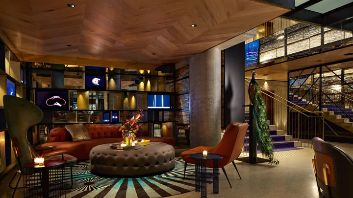 The stylish, quirky lobby interior with striped rug and arty pieces at QT Melbourne