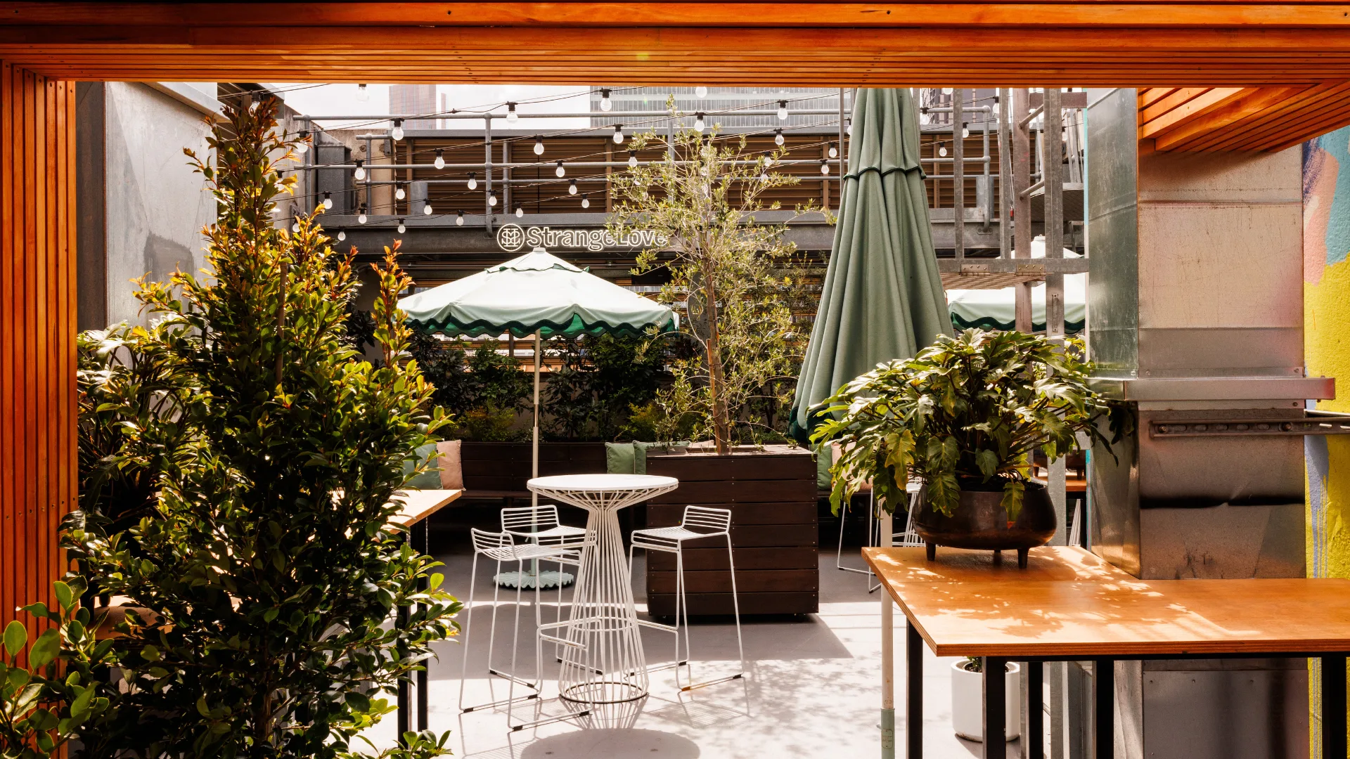 The secret garden with umbrellas, lush plants and cute seating at QT Melbourne