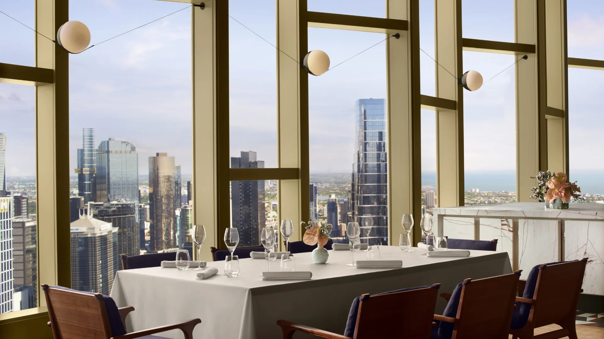 The semi private dining room at Atria Restaurant with a window view of the city at The Ritz-Carlton Melbourne
