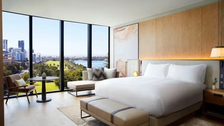 Fresh white and light wood interiors of the Deluxe King Park View bedroom suite at Ritz-Carlton Perth