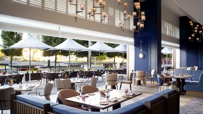 Indoor-outdoor dining with banquette seating and umbrellas at the Hearth restaurant, Ritz-Carlton Perth