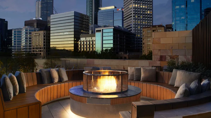 The cosy fire pit with circular bench seating at night at Songbird Bar, Ritz-Carlton Perth