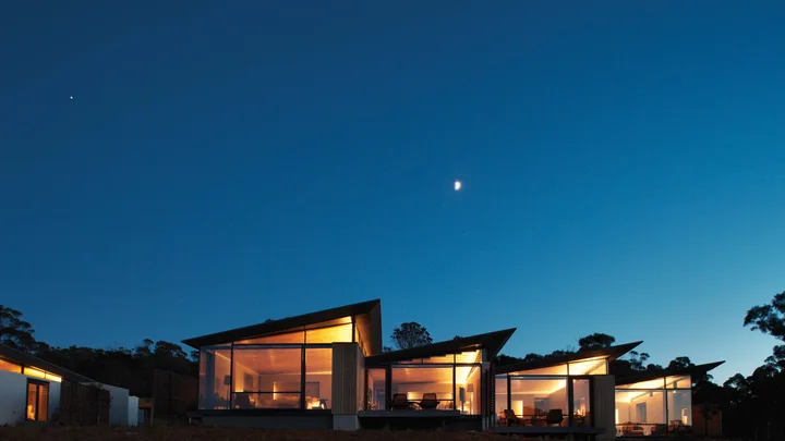 The exterior of the suites at Saffire Freycinet at night with a clear starry sky above
