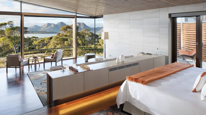 Fresh white interiors of the bedroom at the Private Pavilion Signature Suite with mountain views at Saffire Freycinet
