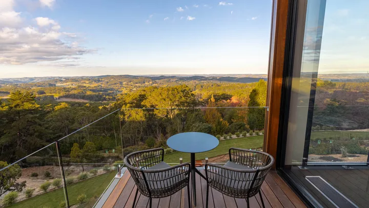 The balcony with a table seating for two overlooking the countryside at Sequoia Lodge.