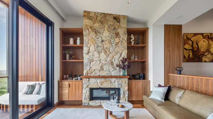 A modern stone fireplace and floor-to-ceiling windows in the lounge suite at Sequoia Lodge.