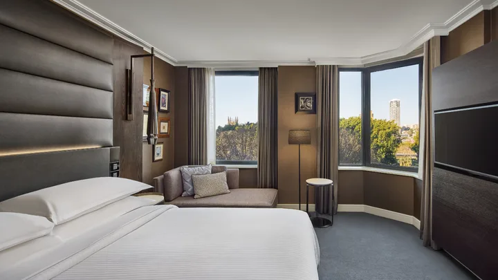 The classic, elegant interior of the Executive Suite bedroom with Hyde Park views at Sheraton Grand Sydney