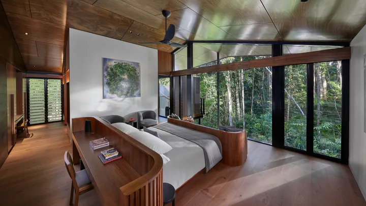 The crisp white bedlinen and wooden floors of the Daintree Pavilion bedroom, at Silky Oaks Lodge, Daintree