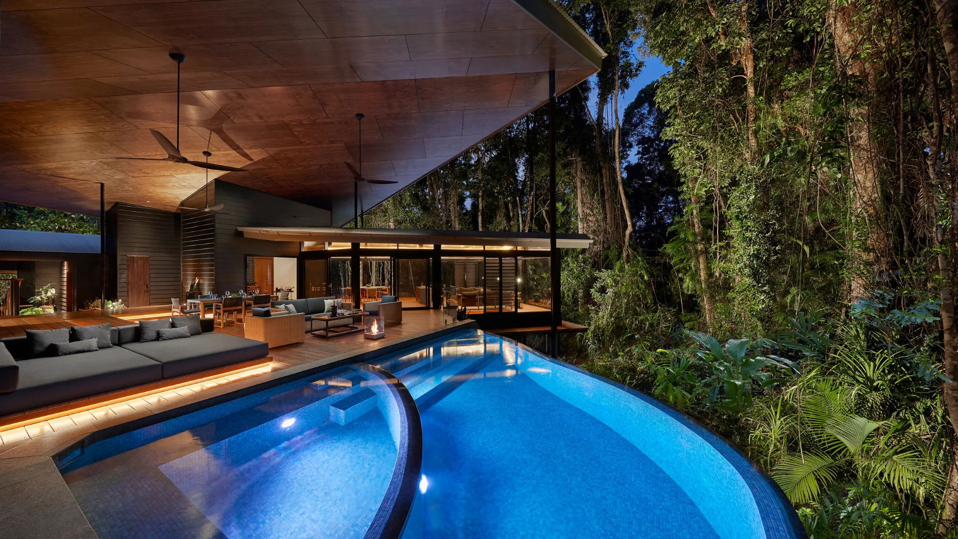 The outdoor pool and deck at night at Silky Oaks Lodge, Daintree
