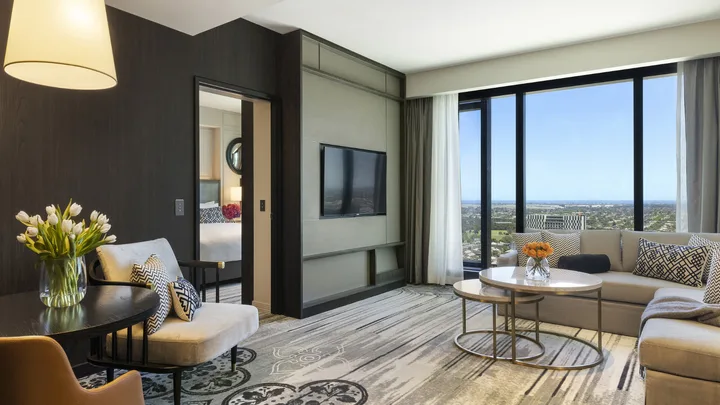 The cool grey, cosy interior of the Prestige Suite lounge at the Sofitel Adelaide