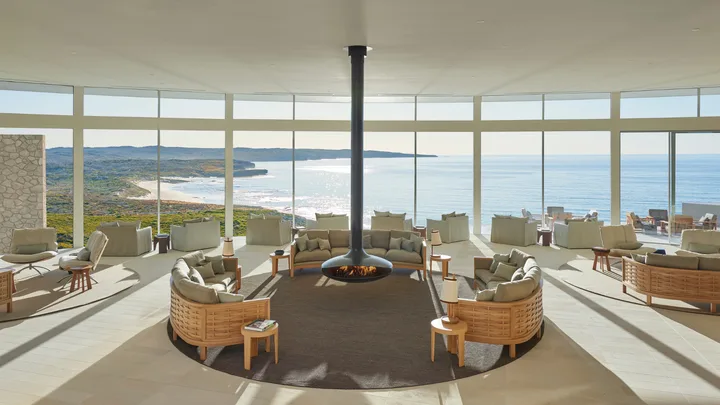The Great Room at Southern Ocean Lodge features a cosy fireplace and floor to ceiling windows with ocean views