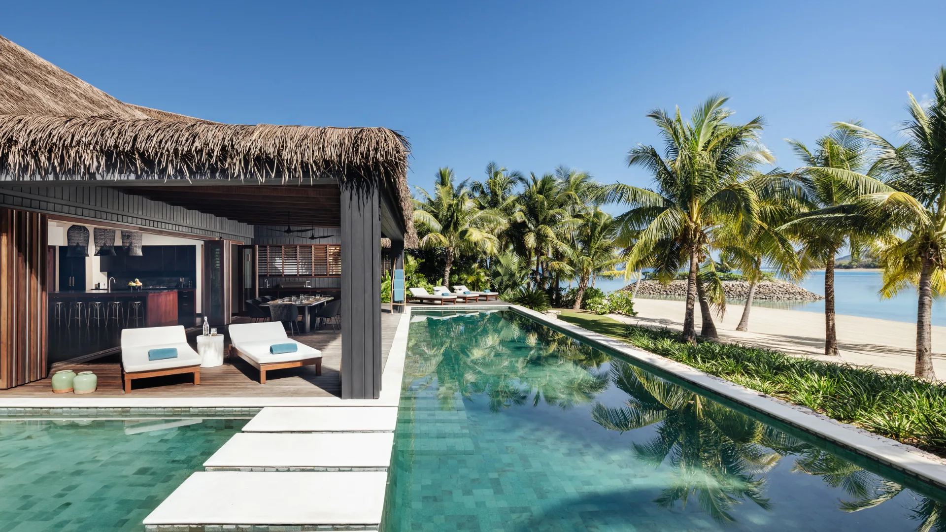 A villa and the pool by the beach at Six Senses Fiji, a wellness retreat
