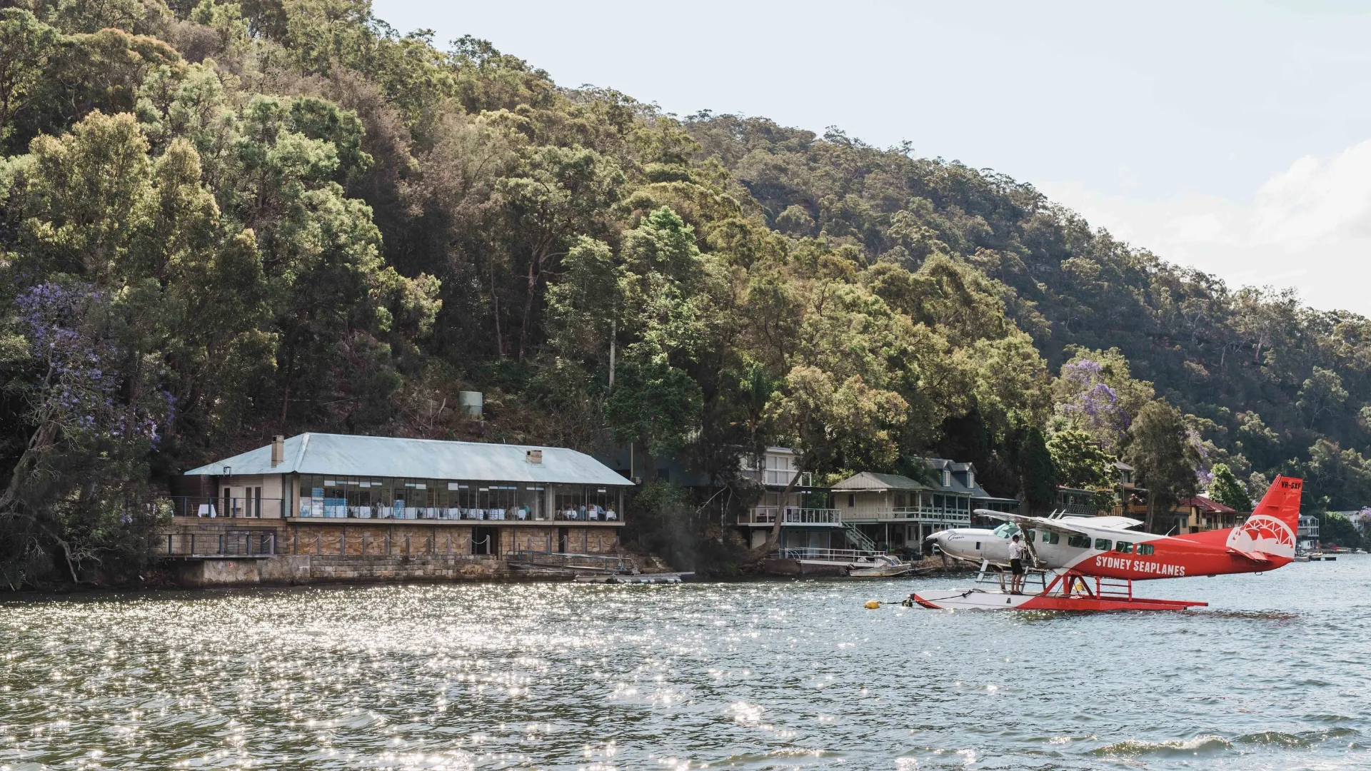 A seaplane sits on the water by Berowra Waters Inn