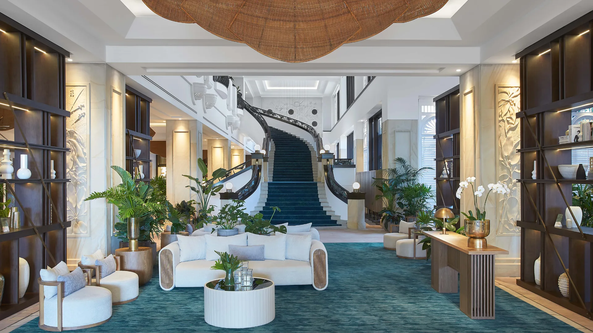 The grant lobby at JW Marriott Resort & Spa with white lounges and a sweeping staircase.
