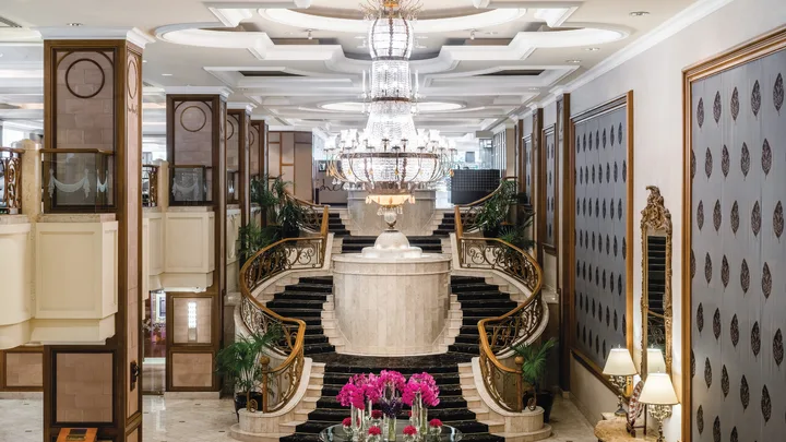 The grand lobby with sweeping staircase and chandelier at The Langham Melbourne.