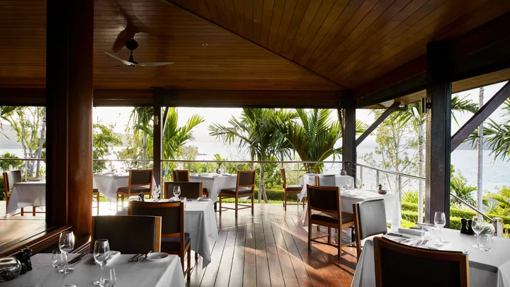 The open air aspect of the Long Pavilion Restaurant, surrounded by palm trees at Qualia.