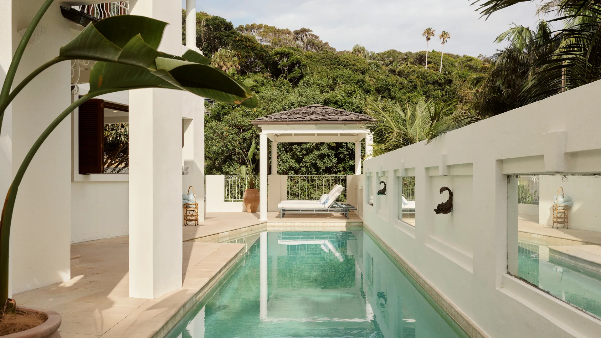 The elegant pool with sun loungers and whitewashed walls at the Guesthouse, Raes on Wategos.