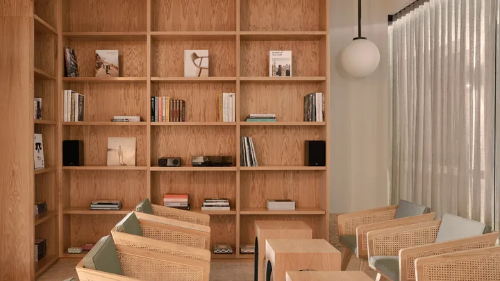The neutral-toned library with timber shelvingat The Calile, Brisbane.