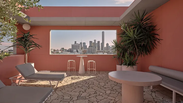 Pink walls, terrazzo-style flooring and sun loungers on an outdoor terrace at The Calile, Brisbane.