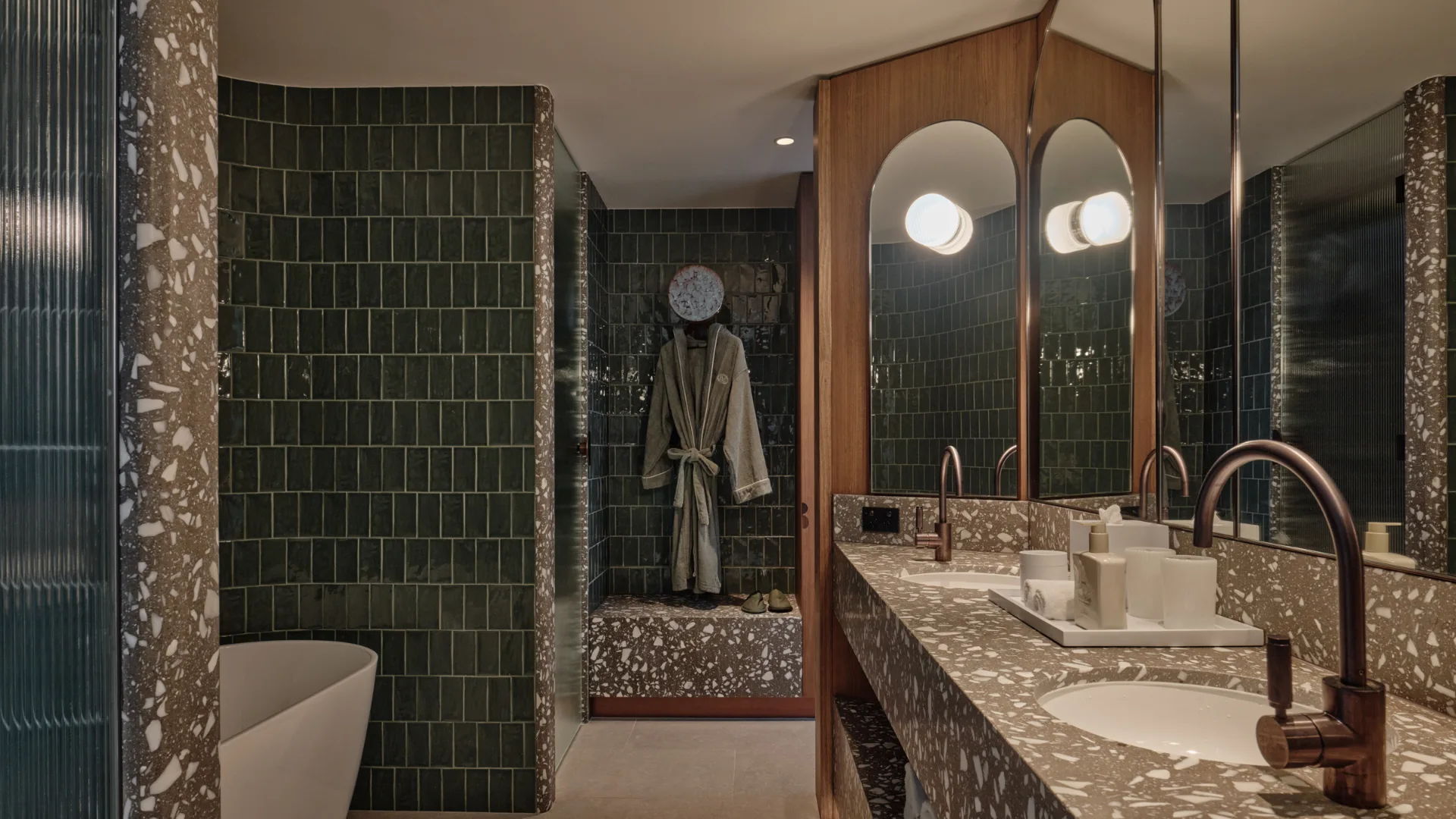 The sleek olive-tiled bathroom with lush hooded robes at The Eve Hotel, Sydney