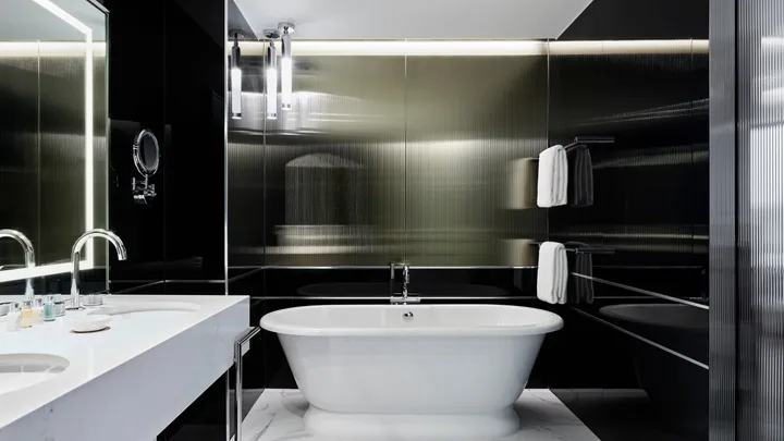The Deluxe room bathroom with freestanding bathtub and black-and-white decor at the Royce Hotel, St Kilda