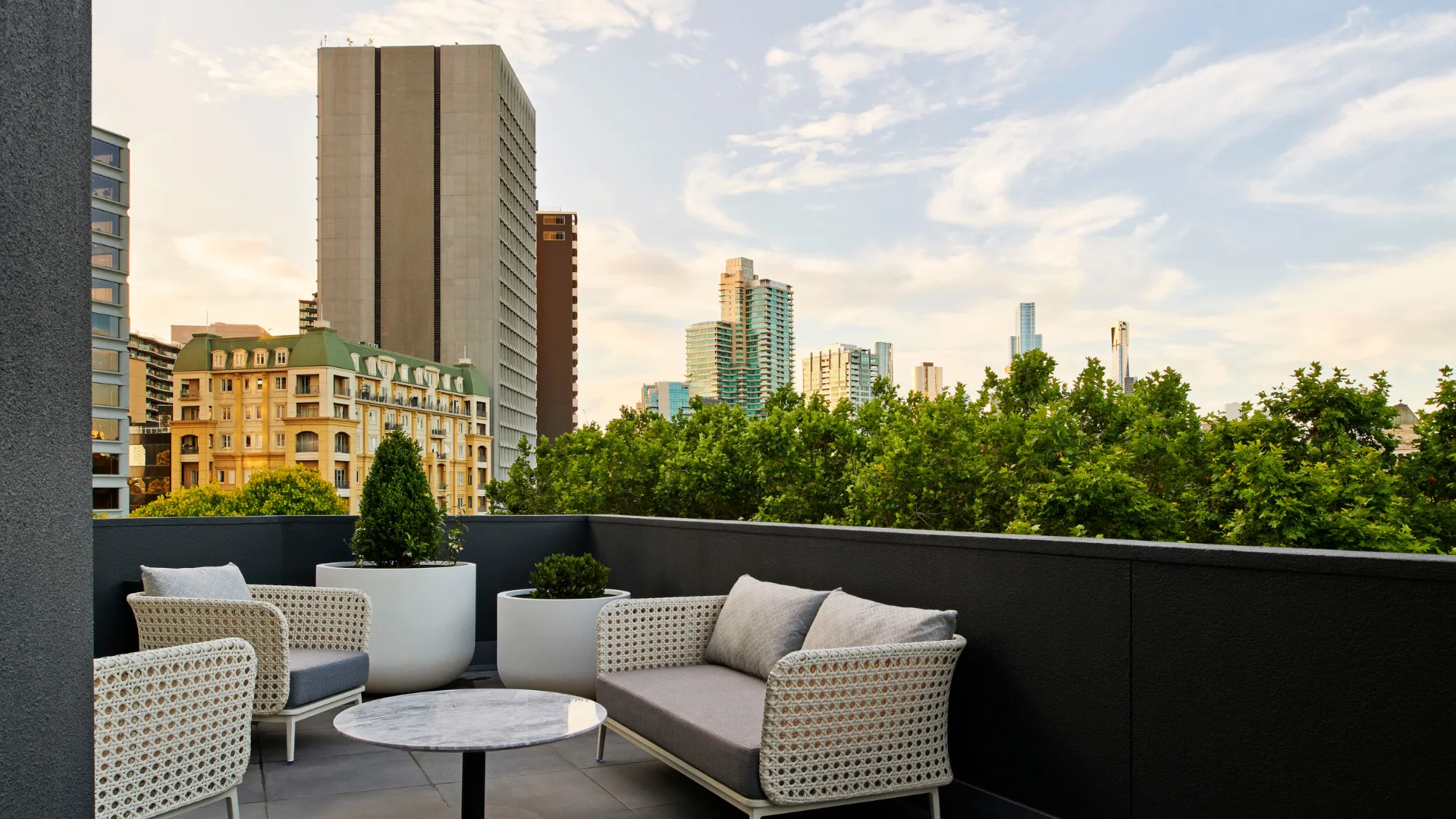 The private terrace at the Royce Suite overlooking treetops and buildings at the Royce Hotel, St Kilda
