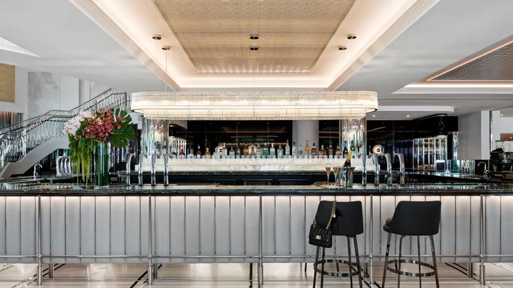 The elegant Showroom Bar with sweeping staircase at the Royce Hotel, St Kilda
