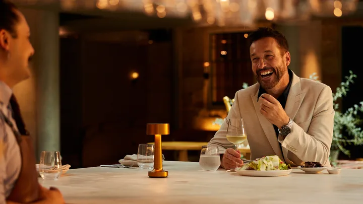 A man sits at a bar enjoying a laugh and a meal at Peppina Restaurant at The Tasman Hotel.