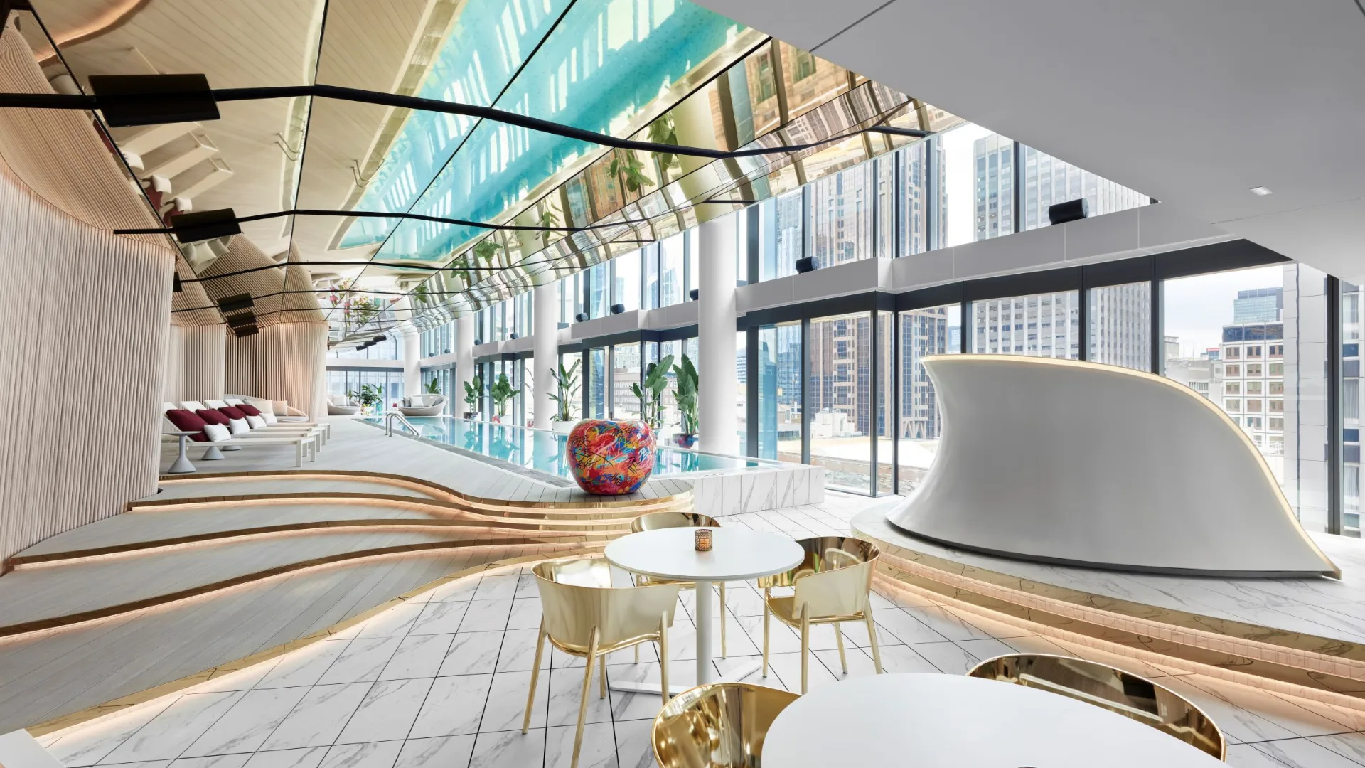 The bright, luxe indoor 'Wet' pool with sun loungers and DJ Booth at W Melbourne.