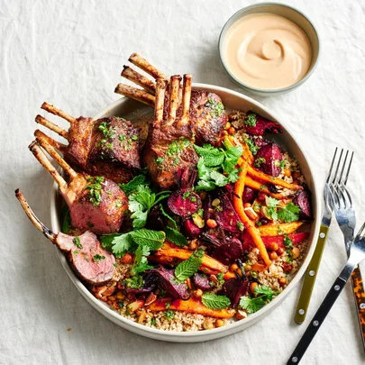 Spiced lamb racks with roast vegetables, couscous and harissa yoghurt