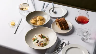 A spread of dishes and wine on a white tablecloth at Melbourne restaurant Harriott