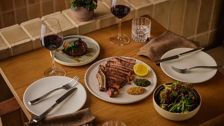 A spread of dishes including a steak at From Here by Mike at 1 Hotel Melbourne.
